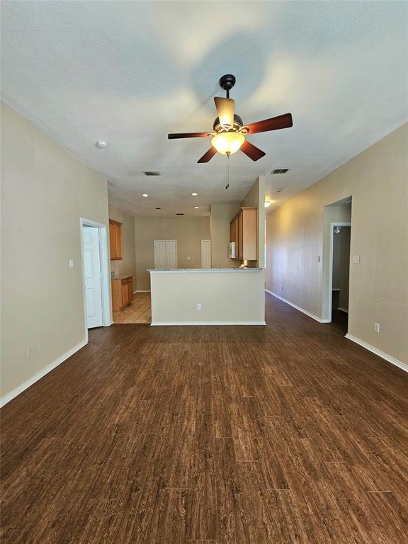 14224 Polo Ranch Street Fort Worth, TX 76052 - Photo 8 of 35 a view of a big room with wooden floor and a ceiling fan