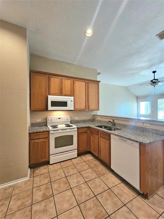 14224 Polo Ranch Street Fort Worth, TX 76052 - Photo 9 of 35 a kitchen with stainless steel appliances granite countertop a stove a sink and a microwave