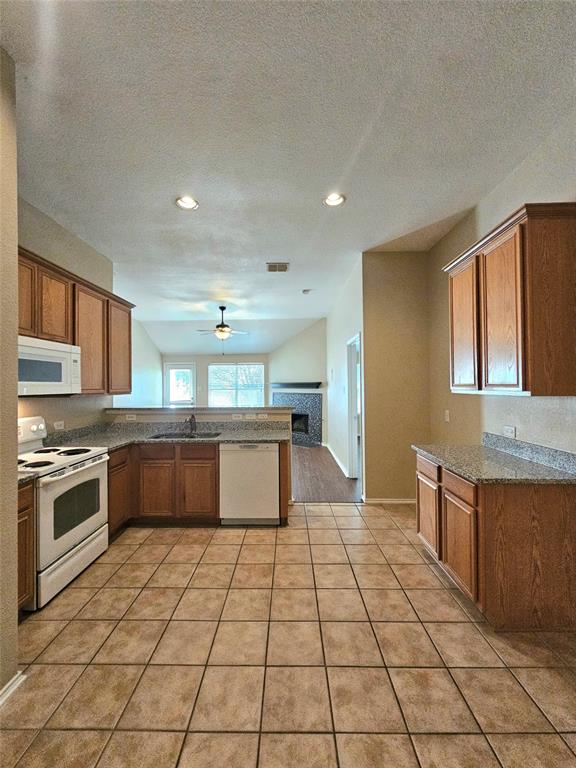 14224 Polo Ranch Street Fort Worth, TX 76052 - Photo 10 of 35 a large kitchen with stainless steel appliances granite countertop a stove a sink and a refrigerator