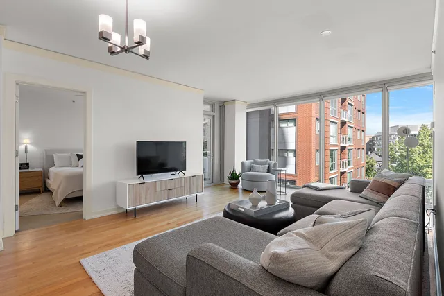a living room with furniture flat screen tv and a large window