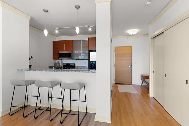 a kitchen with stainless steel appliances kitchen island granite countertop a refrigerator and a stove top oven