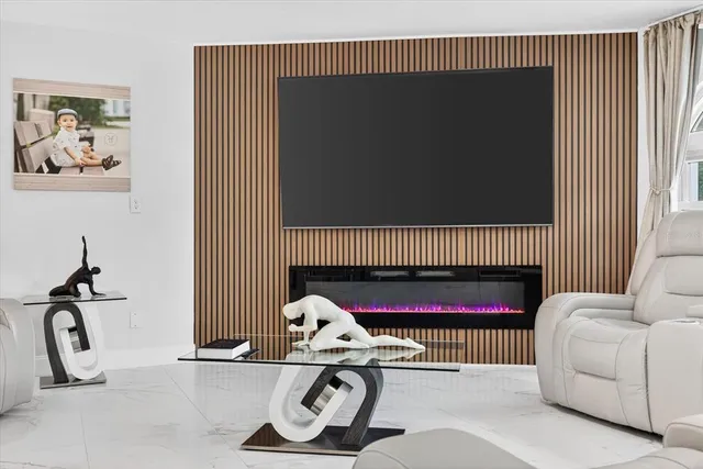 a living room with furniture a flat screen tv and kitchen view