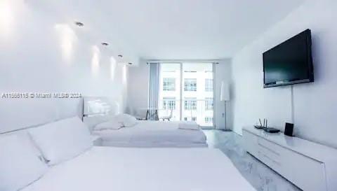 a spacious bedroom with a large bed and a flat screen tv