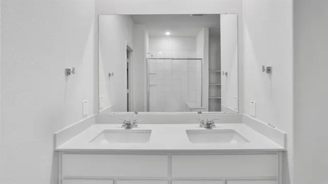 a bathroom with double sink and a mirror