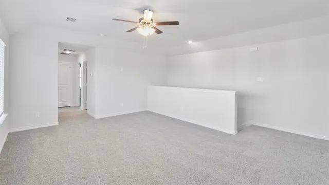 an empty room with a ceiling fan and a chandelier fan
