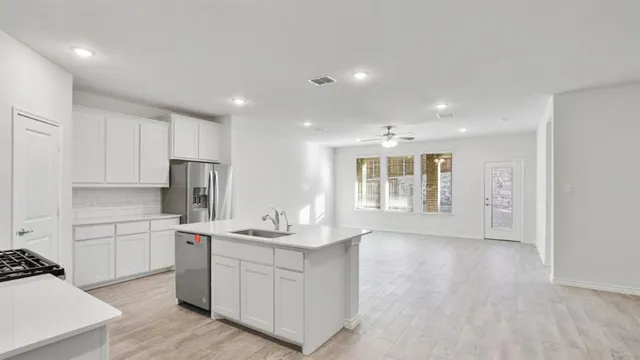 a kitchen with a sink stainless steel appliances and white cabinets