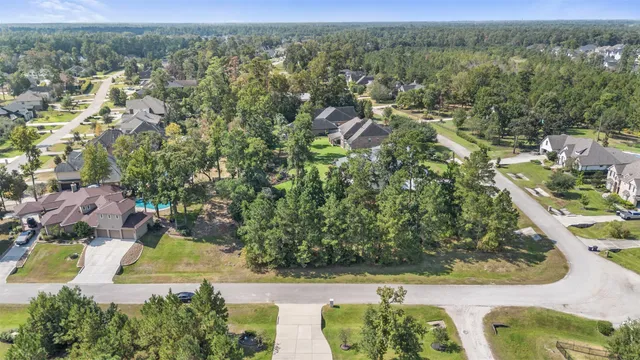 an aerial view of residential houses with outdoor space and trees