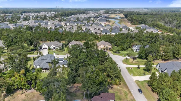 an aerial view of residential houses with outdoor space and trees