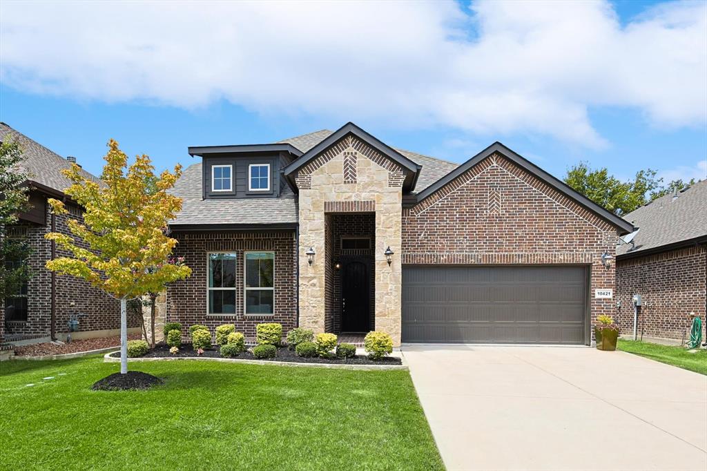 a front view of a house with a yard and garage