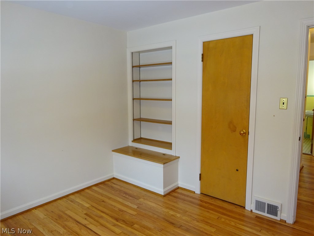 2927 Weymouth Road Cleveland, OH 44120 - Photo 20 of 29 Second bedroom has hardwood floors, built-in shelves, and bench storage.