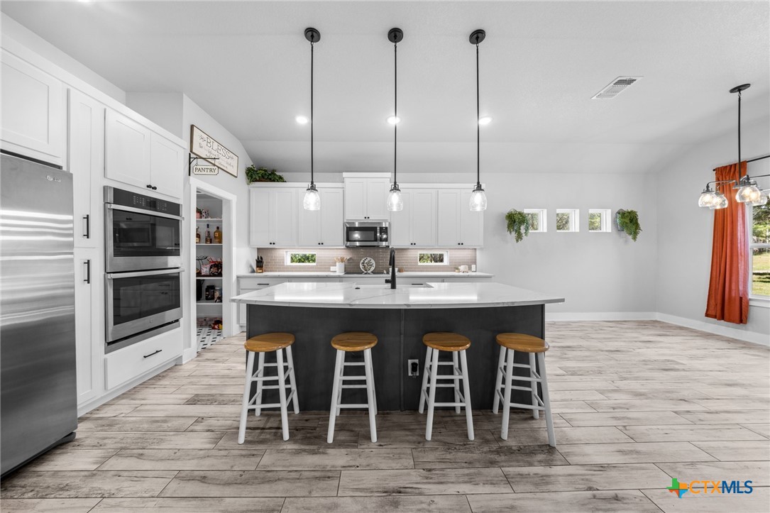 614 South Wheat Road Belton, TX 76513 - Photo 12 of 46 a kitchen with kitchen island granite countertop a sink counter top space appliances and cabinets