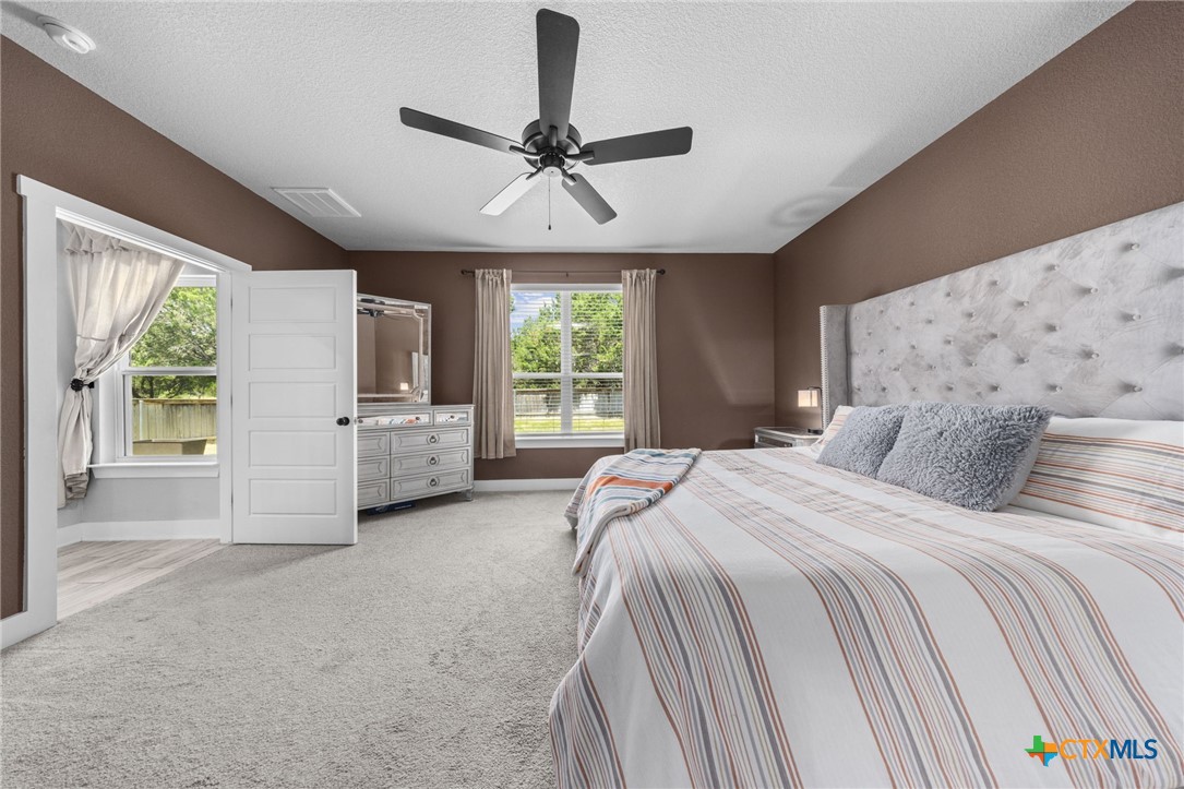 614 South Wheat Road Belton, TX 76513 - Photo 22 of 46 a spacious bedroom with a large bed and a chandelier