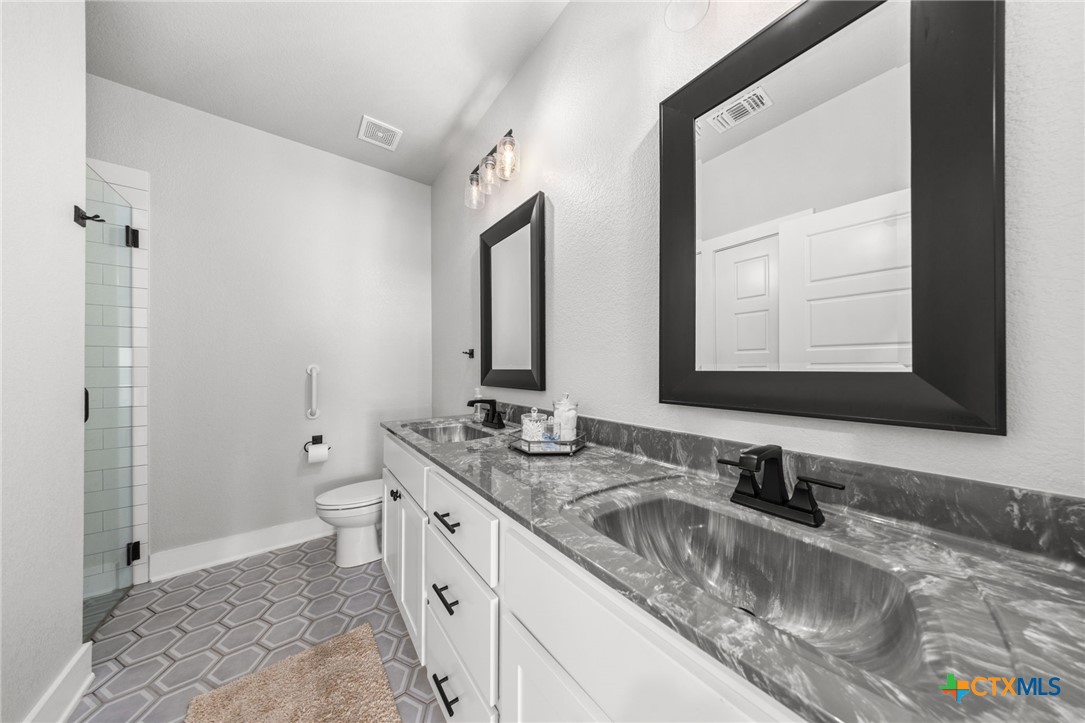 614 South Wheat Road Belton, TX 76513 - Photo 31 of 46 a bathroom with a granite countertop sink mirror and a toilet