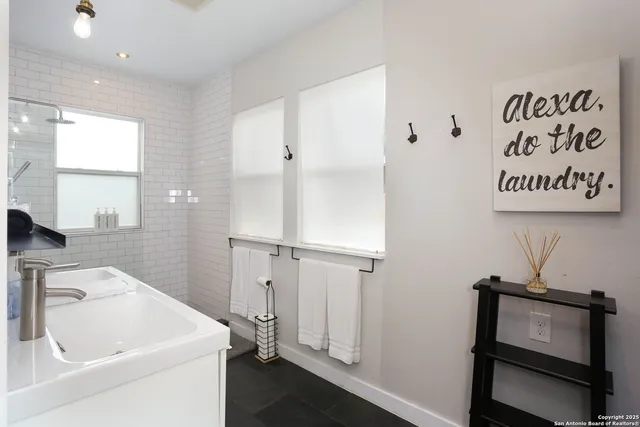 a bathroom with a toilet a sink a mirror and a window