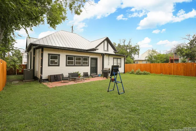 a front view of a house with a garden and trees