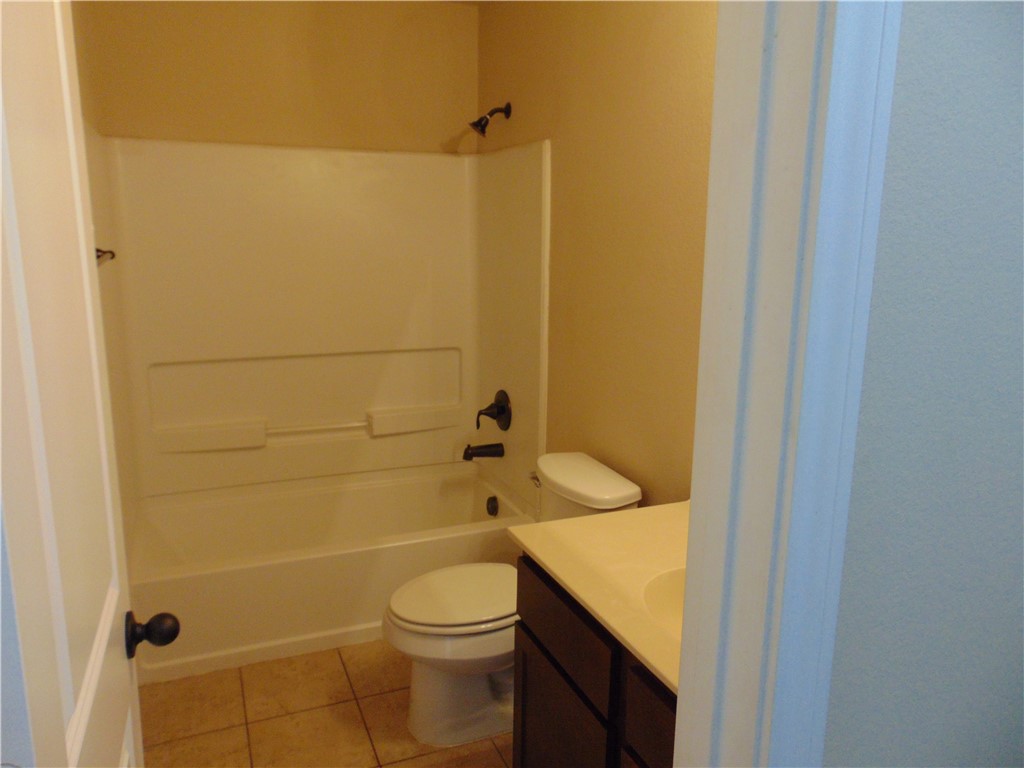 Undisclosed Address Kyle, TX 78640 - Photo 8 of 11 a bathroom with a granite countertop toilet and a shower