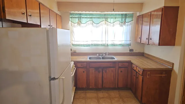 a kitchen with a sink a refrigerator and a stove