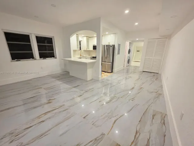 a view of a kitchen with wooden floor and windows