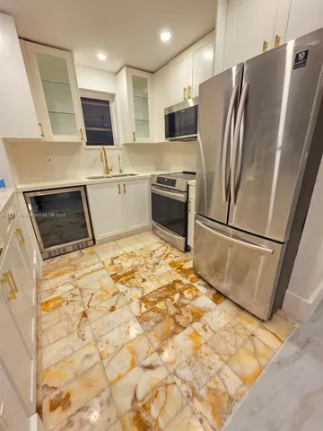 a kitchen with granite countertop a refrigerator and a stove top oven