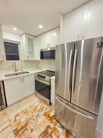 a kitchen with stainless steel appliances a refrigerator sink and microwave