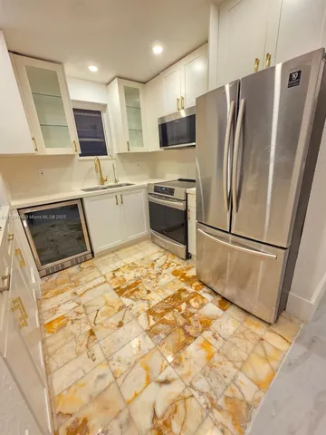 a kitchen with granite countertop a refrigerator and a sink