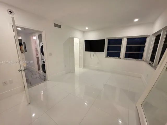 a bathroom with a tub and a view of living room