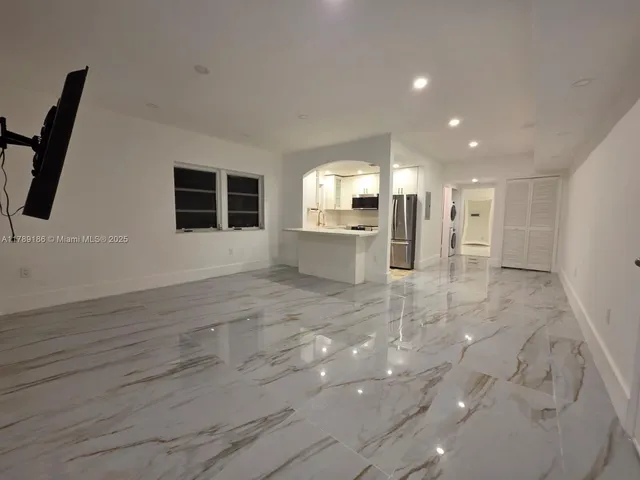 a view of empty room with wooden floor and window