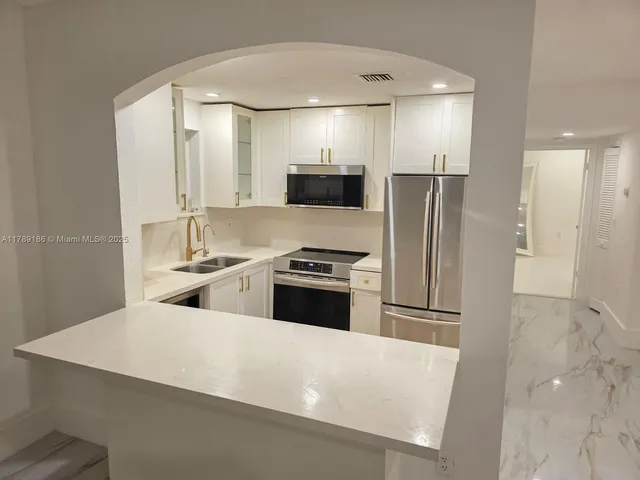 a large kitchen with a refrigerator a stove and a sink