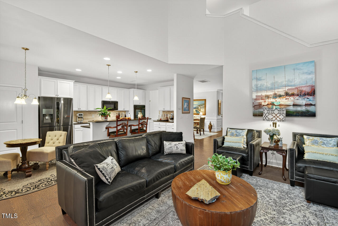 127 Willow View Lane Apex, NC 27539 - Photo 12 of 39 a living room with furniture kitchen view and a chandelier
