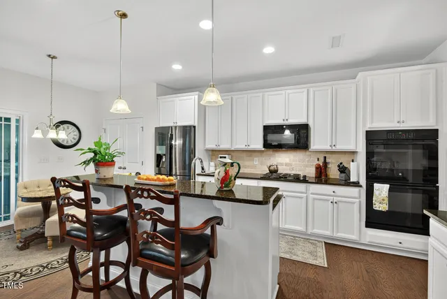 a living room with furniture kitchen view and a chandelier
