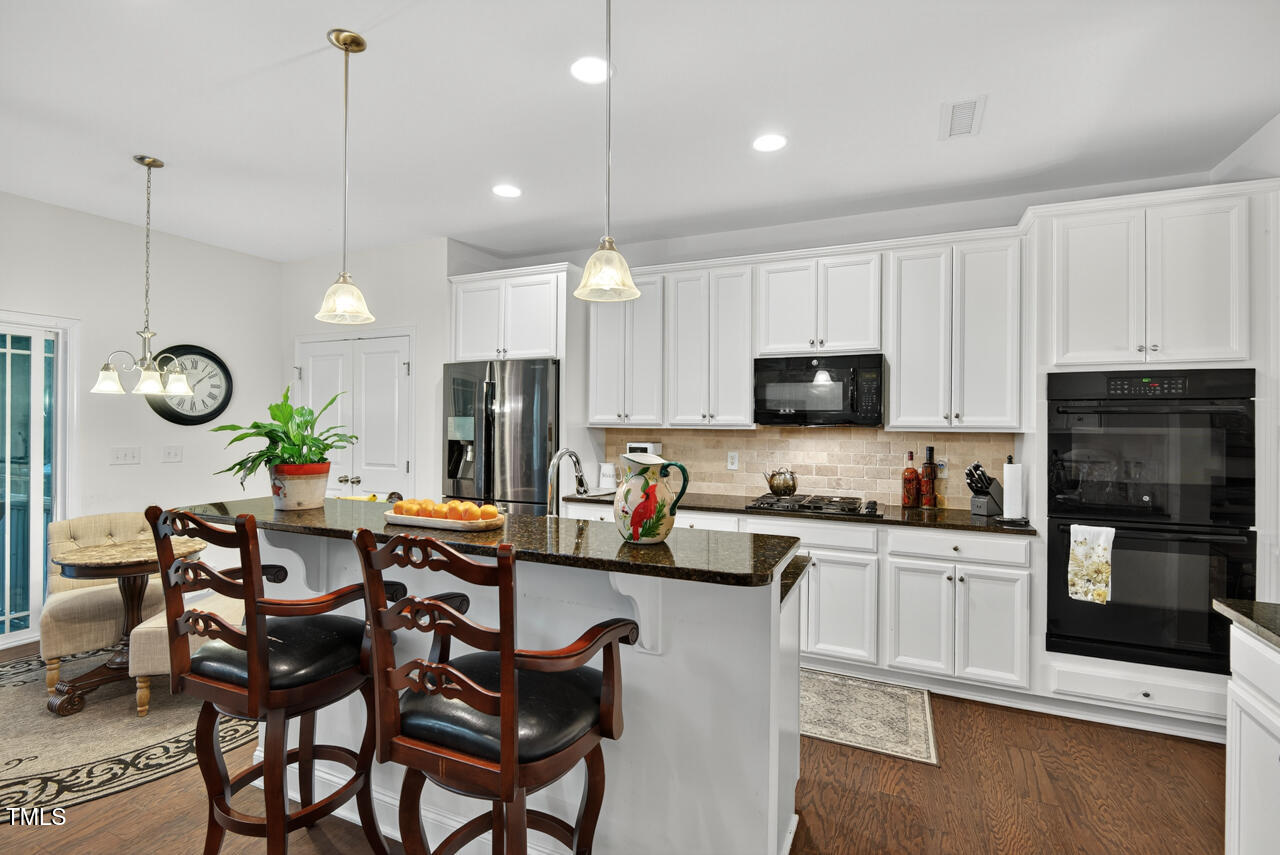 127 Willow View Lane Apex, NC 27539 - Photo 13 of 39 a kitchen with stainless steel appliances granite countertop a stove a sink a dining table and chairs