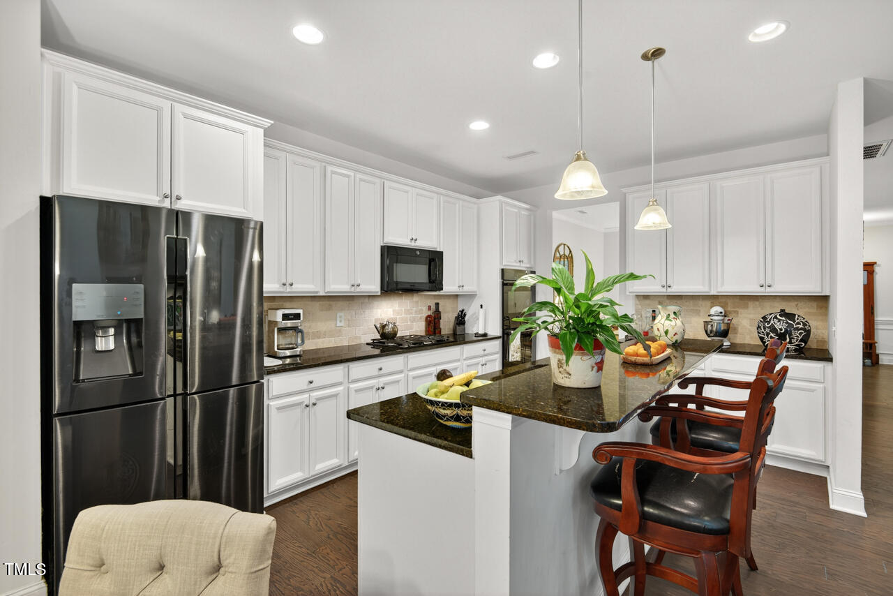 127 Willow View Lane Apex, NC 27539 - Photo 16 of 39 a kitchen with a refrigerator a stove a sink and white cabinets
