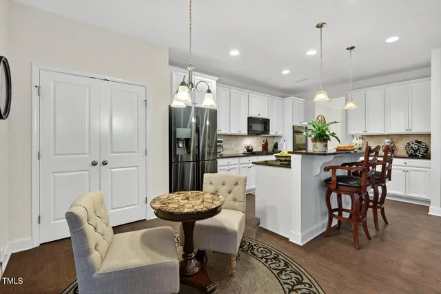 a kitchen with a refrigerator a stove a sink and white cabinets
