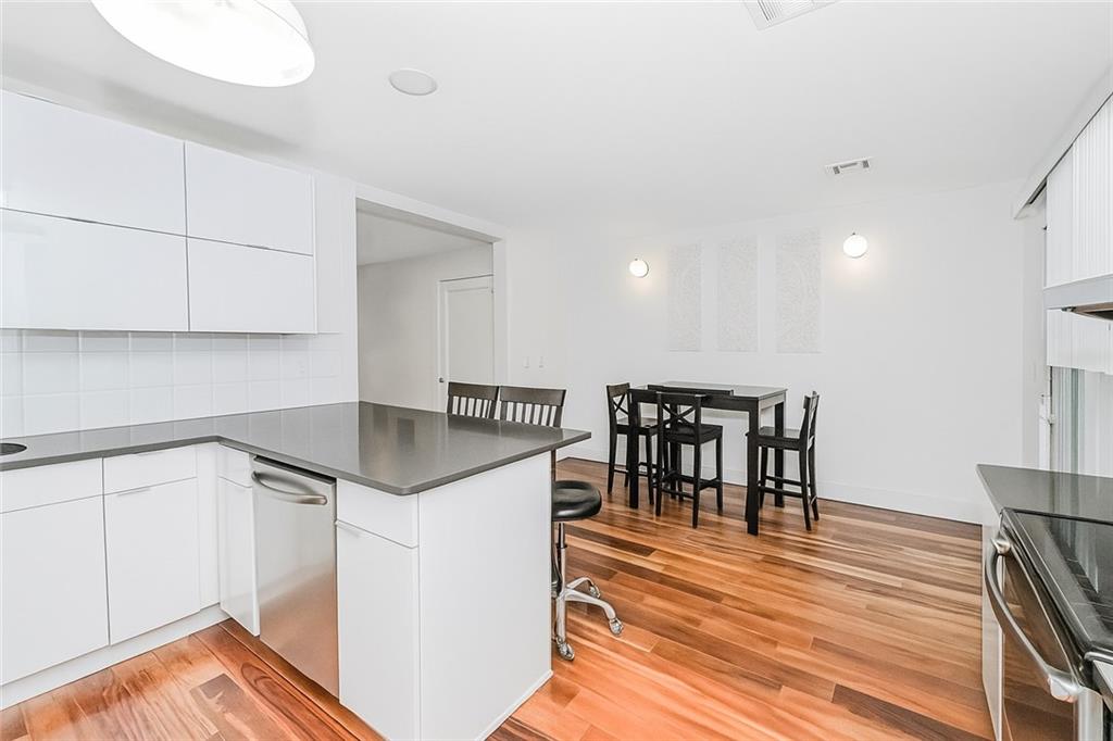 934 Jefferson Avenue Brooklyn, NY 11221 - Photo 6 of 36 a kitchen with granite countertop a table chairs stove and wooden floor