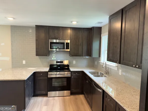 a kitchen with granite countertop a stove top oven and sink