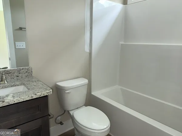a white toilet sitting next to a bath tub