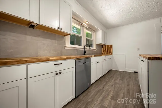 a kitchen with a sink a window and cabinets