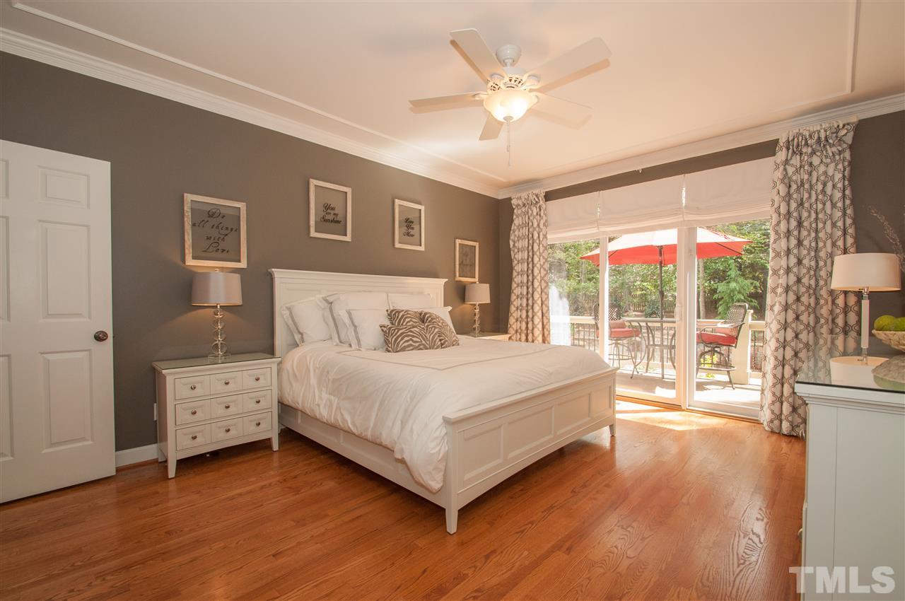 408 Chatterson Drive Raleigh, NC 27615 - Photo 11 of 25 a bedroom with a large bed and a chandelier