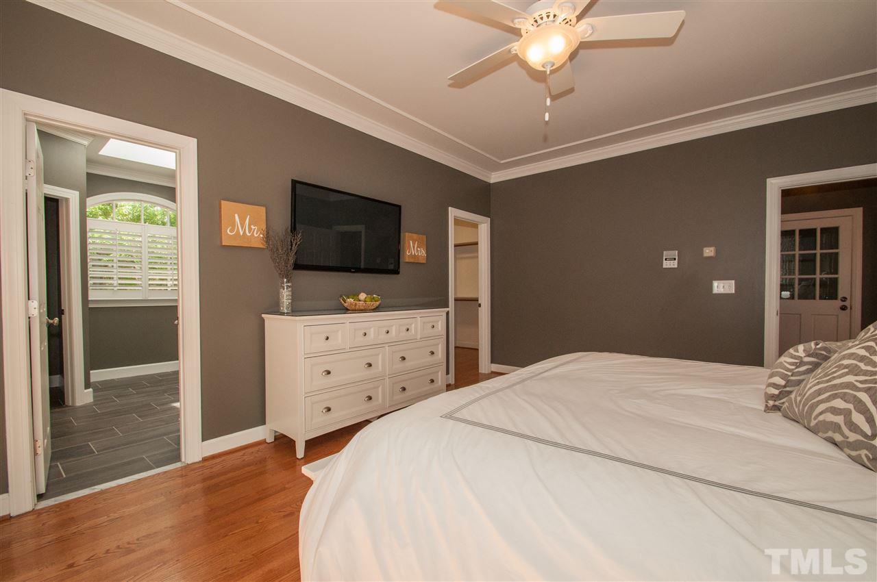 408 Chatterson Drive Raleigh, NC 27615 - Photo 12 of 25 a bedroom with a bed and a flat tv screen on dresser