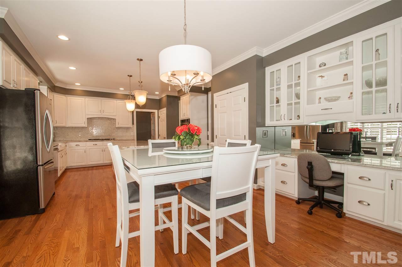 408 Chatterson Drive Raleigh, NC 27615 - Photo 6 of 25 a kitchen with stainless steel appliances kitchen island granite countertop a dining table chairs and granite counter tops