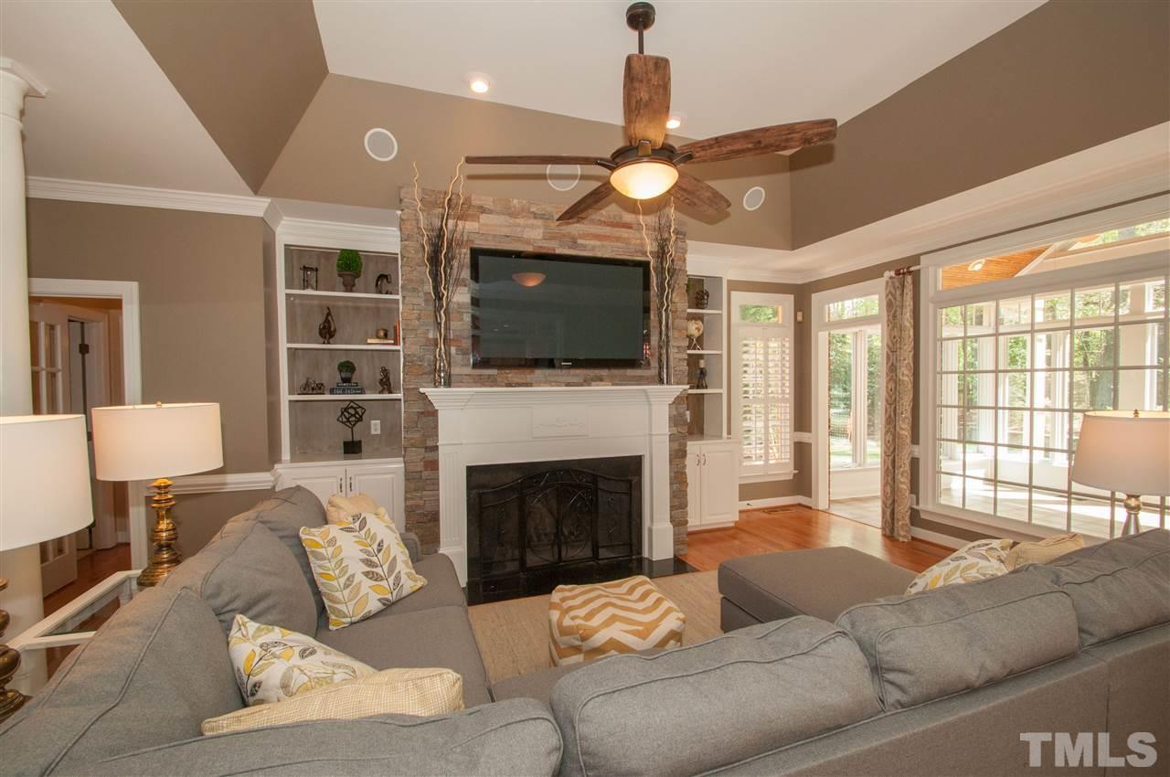 408 Chatterson Drive Raleigh, NC 27615 - Photo 7 of 25 a living room with furniture a fireplace and a flat screen tv