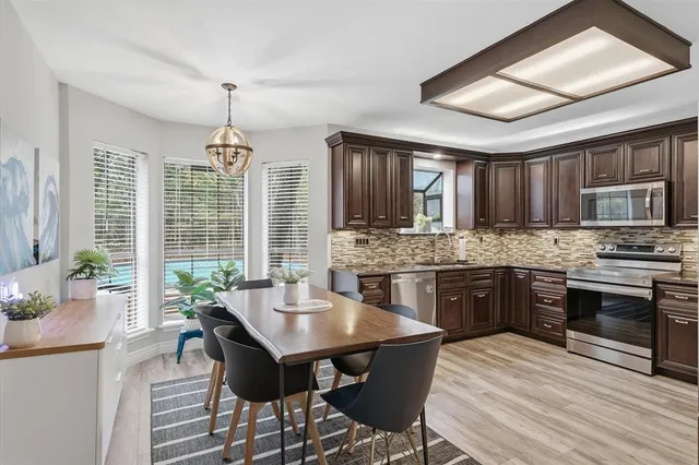 a kitchen with stainless steel appliances granite countertop a refrigerator and a stove top oven