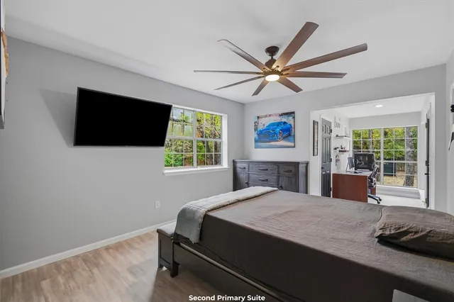 a bedroom with a bed a window and a television