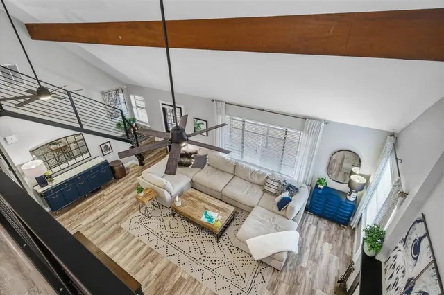 a living room with furniture a flat screen tv and a large window