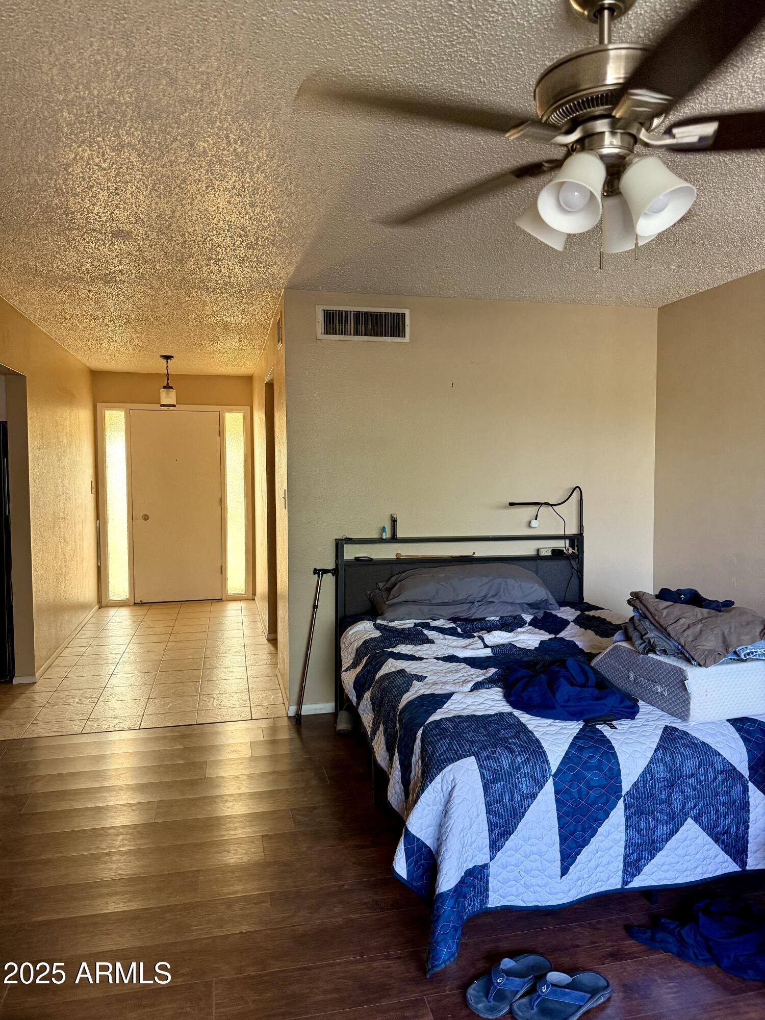 5856 Colby Street Mesa, AZ 85205 - Photo 4 of 18 a bedroom with a bed and wooden floor