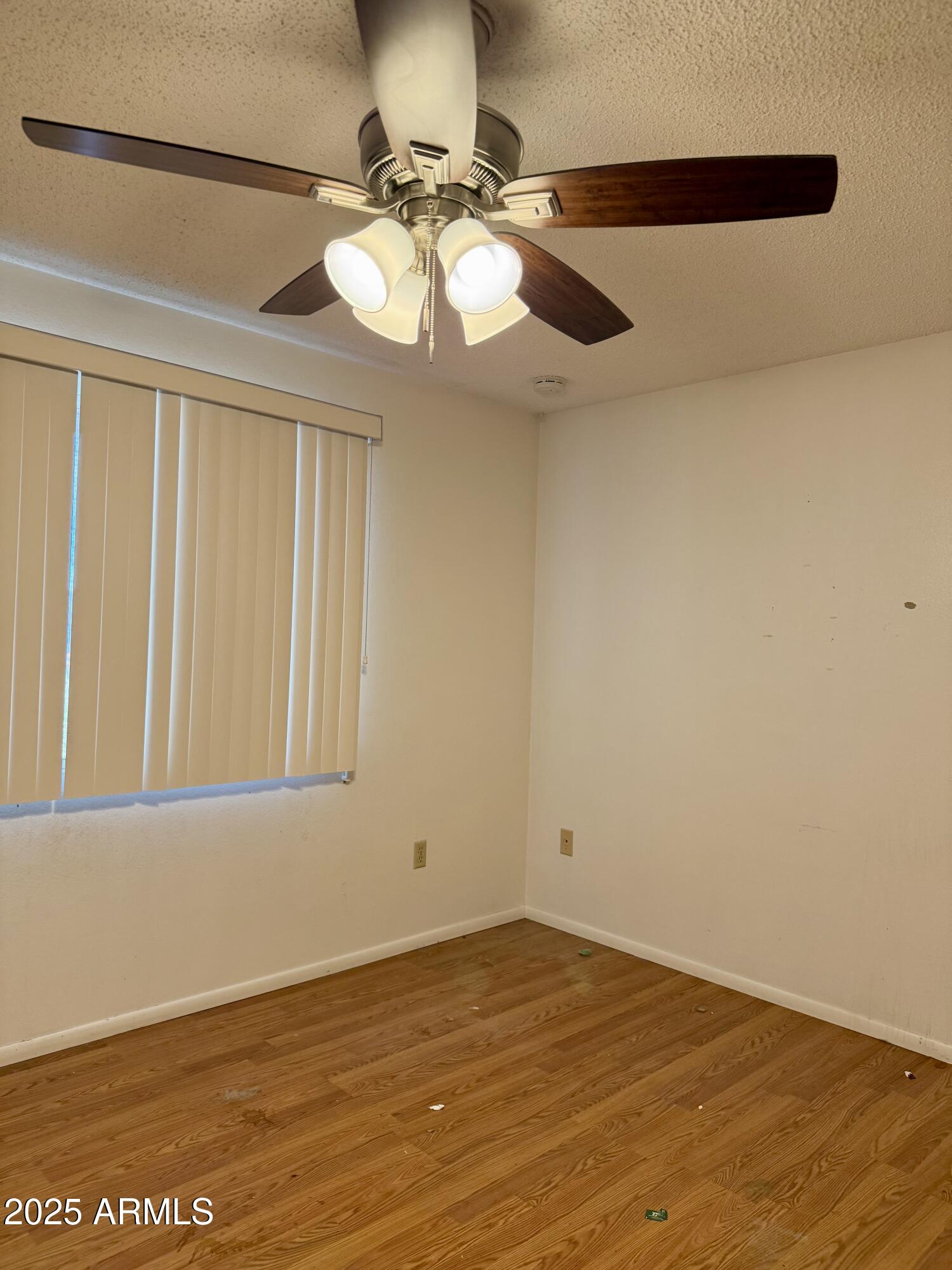 5856 Colby Street Mesa, AZ 85205 - Photo 9 of 18 a view of an empty room with wooden floor and a window