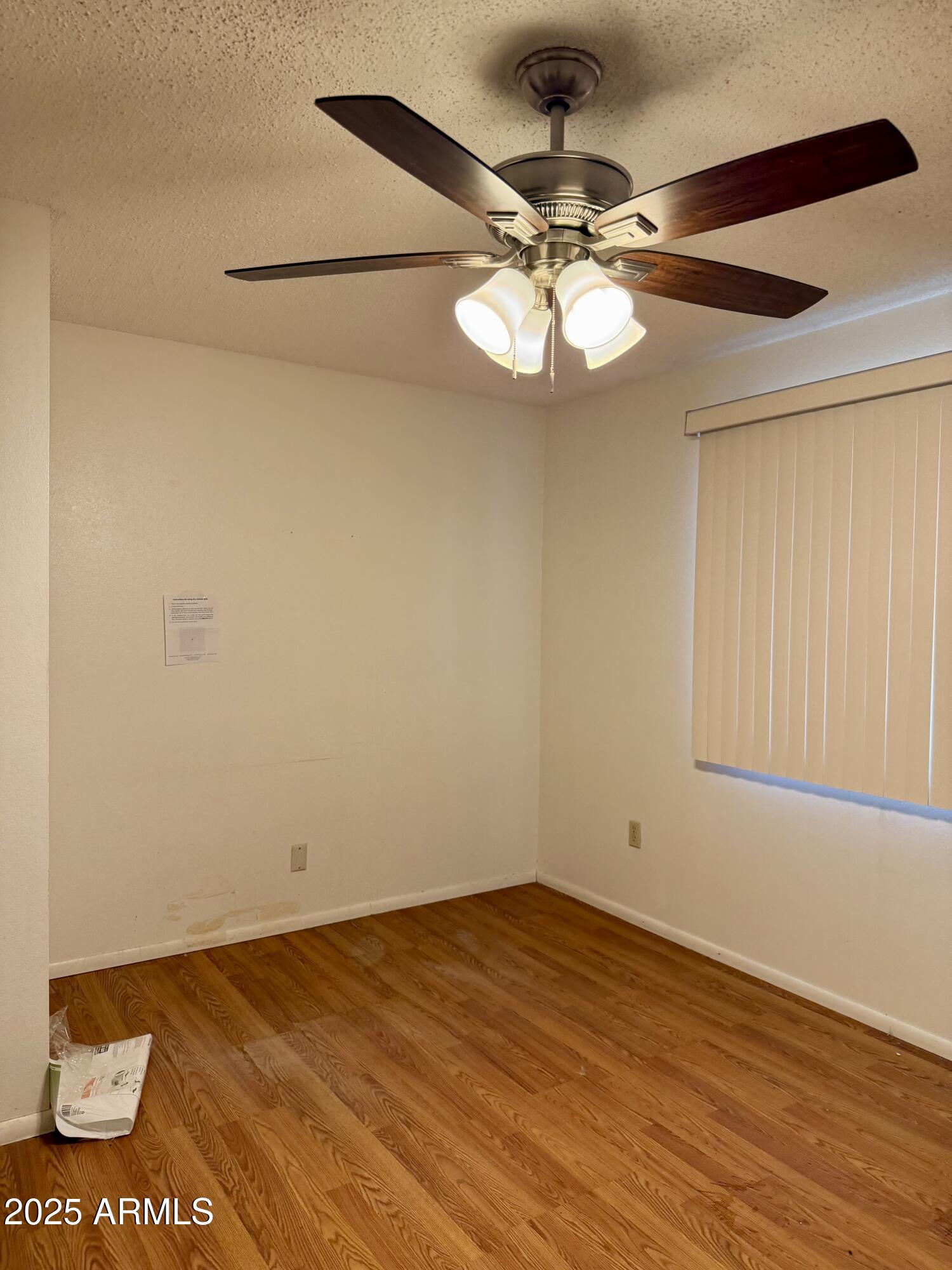5856 Colby Street Mesa, AZ 85205 - Photo 10 of 18 an empty room with wooden floor fan and windows