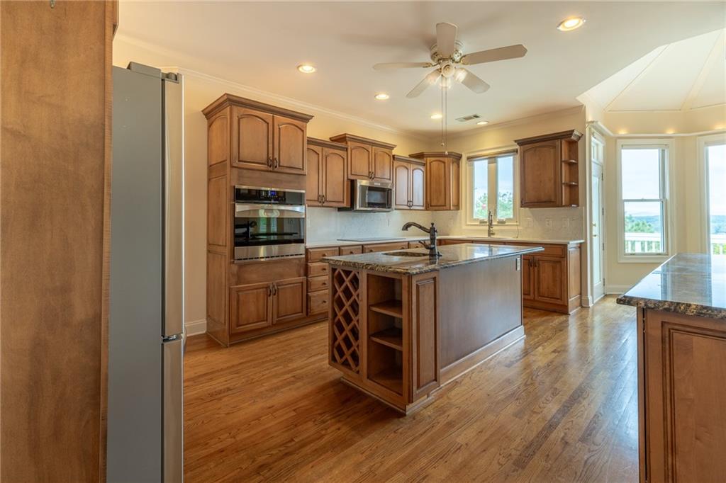 5739 Ridgewater Circle Gainesville, GA 30506 - Photo 26 of 93 a kitchen with stainless steel appliances granite countertop a stove top oven a sink and a refrigerator