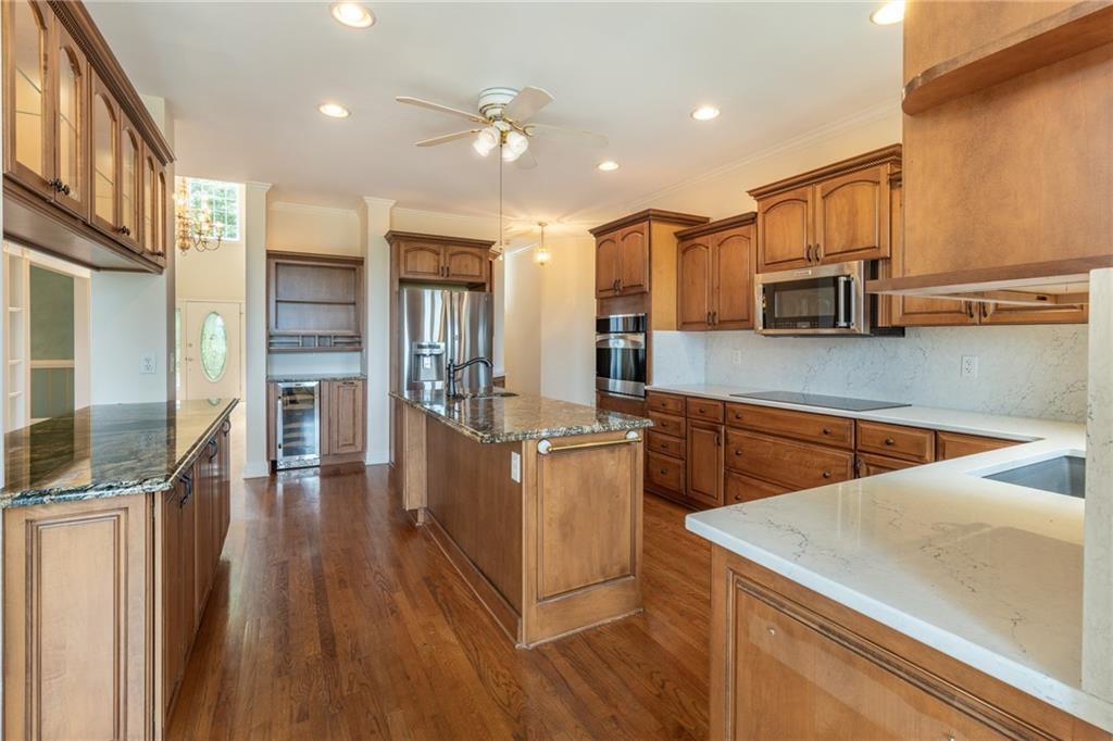 5739 Ridgewater Circle Gainesville, GA 30506 - Photo 32 of 93 a kitchen with stainless steel appliances a stove a sink a refrigerator white cabinets and wooden floor