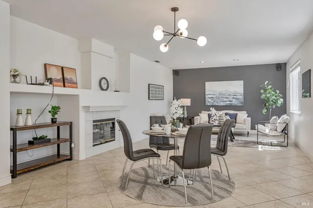 a dining room with wooden floor a chandelier a glass table and chairs